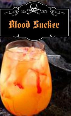 a glass filled with liquid sitting on top of a table next to a sign that says blood sucker