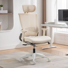 a white office chair sitting on top of a wooden floor next to a computer desk