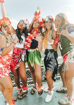 four young women are posing for the camera with leis around their necks and feet