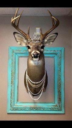 a deer head mounted on the wall with pearls