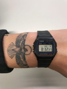 a person with a wrist tattoo has a watch on it's arm and is displaying the time