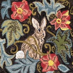 a close up of an animal on a rug with flowers in the middle and leaves around it