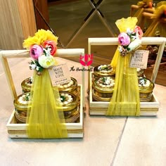 two small boxes with flowers in them sitting on the floor next to each other, one is filled with gold coins