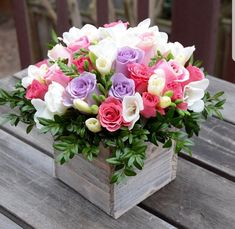 a wooden box filled with lots of colorful flowers