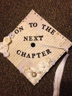 a decorated graduation cap that says on to the next charter, with flowers and pearls