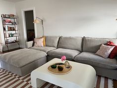 a living room with a couch, ottoman and coffee table