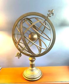 a metal globe on top of a wooden table