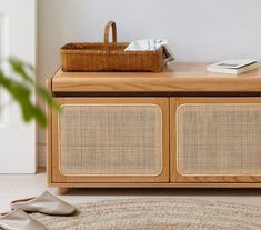 a basket sitting on top of a wooden cabinet next to a rug and door way