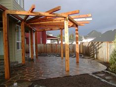 an outdoor patio with wooden pergols and stone pavers