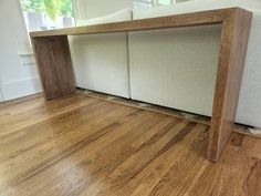 a wooden bench sitting on top of a hard wood floor