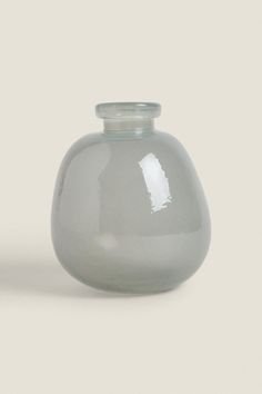 two gray vases sitting next to each other on a white surface with no one around them