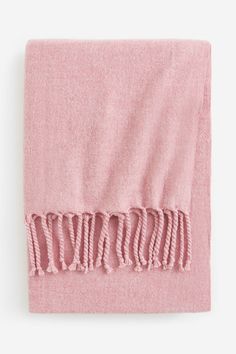 a pink blanket with fringes on it