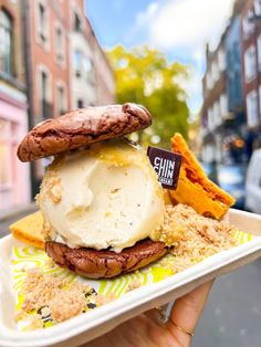 an ice cream sundae with cookies and chips on a plate in front of some buildings