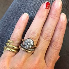 a woman's hand with three different rings on it and a diamond ring in the middle