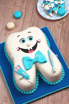 a tooth shaped cake sitting on top of a blue plate