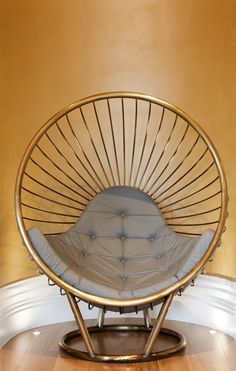 a chair sitting on top of a hard wood floor next to a round metal frame