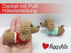 a small crocheted dog is being held by someone's hand with the caption dachsel mit pulli hakealentitung