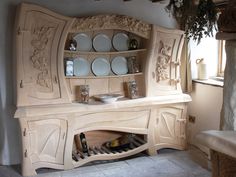 a wooden cabinet with plates on it in a living room next to a fire place