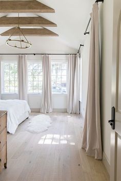 a bedroom with white walls and wooden floors