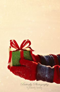 a person's arm wrapped in red and green fabric with a gift box tied to it