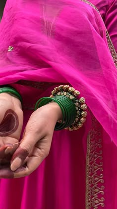 a woman in a pink dress holding out her hand to show the ring on her finger