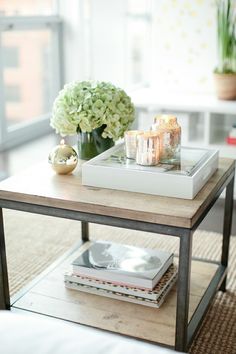 a coffee table with books and flowers on it