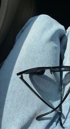 a pair of black glasses sitting on top of a blue cloth in the back seat of a car