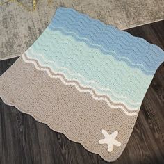 a crocheted blanket is laying on the floor with a starfish in it