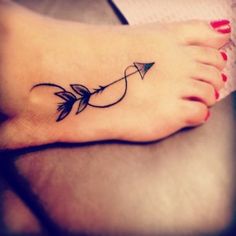 a woman's foot with an arrow tattoo on it