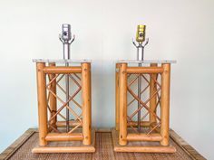 two wooden table lamps sitting on top of a bamboo mat next to eachother