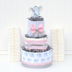 a three tiered cake with an elephant on top and other items around it for decoration