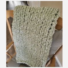 a crocheted blanket sitting on top of a wooden chair