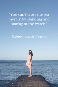 a woman standing on top of a pier next to the ocean with a quote above her that reads, you can't cross the sea merley by standing and staring at the water