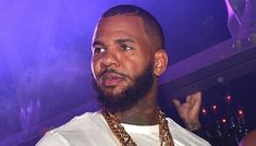 a close up of a person wearing a necklace and a white t - shirt at a party