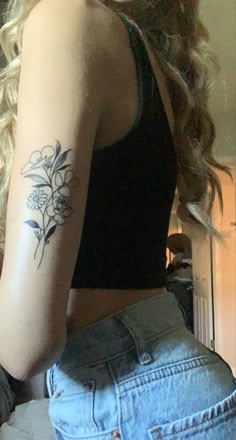 a woman with a flower tattoo on her left arm and right arm behind her back