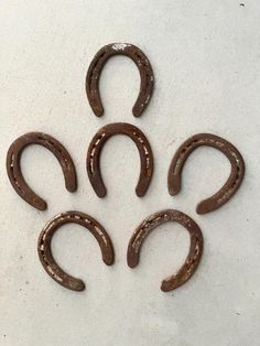 five horseshoes are arranged in the shape of an oar on a white surface