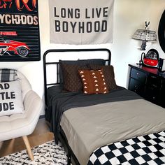 a bed room with a neatly made bed and posters on the wall