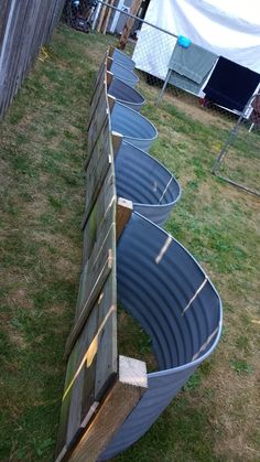 several metal tubs are lined up in the grass