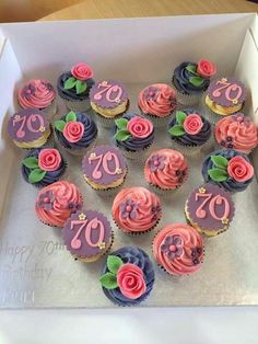 a box filled with cupcakes covered in pink and blue frosting