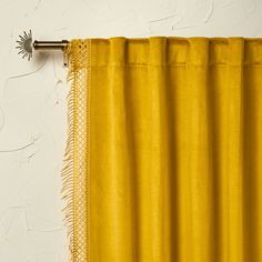 a yellow curtain hanging on the side of a white wall