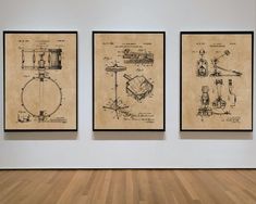 three framed drawings on a wall in an empty room with wooden floors and hard wood flooring