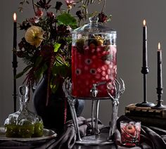 a table topped with a vase filled with flowers next to candles and other decor items