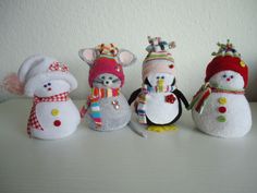 four snowmen with hats and scarves are standing next to each other on a table