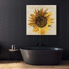 a bathroom with a sunflower painting on the wall and a black bathtub in front of it