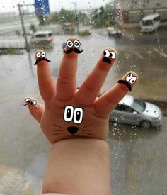 a hand with eyes drawn on it in the rain