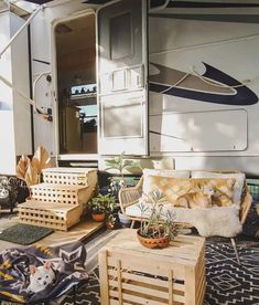 a living area with couches, tables and chairs in front of a camper