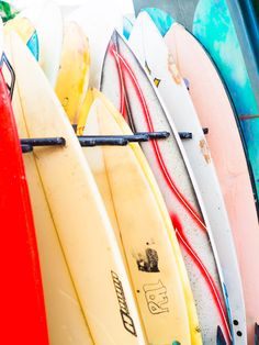 several surfboards are lined up in a row and ready to be used on the beach