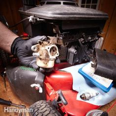 a man in black gloves is working on an engine and other parts that are underneath the car