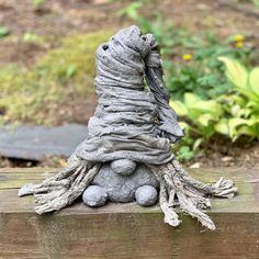 a close up of a small statue on a wooden surface with trees in the background