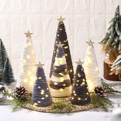 small christmas trees with lights on them and pine cones